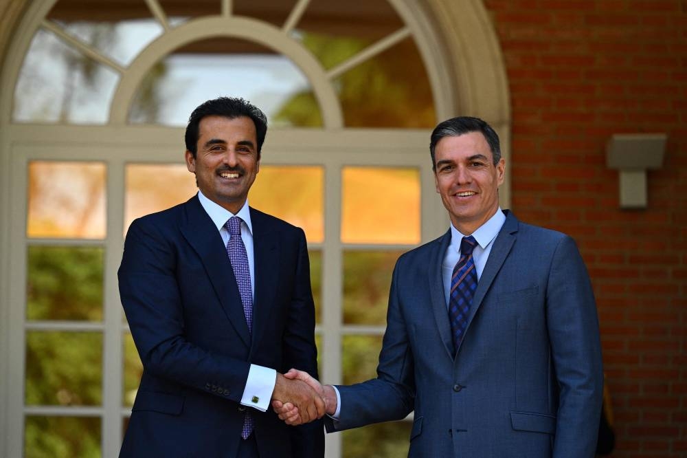 Spain’s Prime Minister Pedro Sanchez (right) shakes hands with Emir of Qatar Tamim bin Hamad Al Thani as he arrives for their meeting at La Moncloa Palace in Madrid, on May 18, 2022. — AFP pic