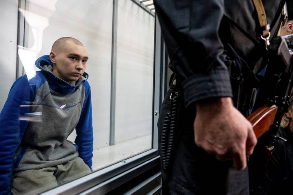 Russian soldier Vadim Shishimarin, 21, suspected of violations of the laws and norms of war, sits inside a defendants' cage during a court hearing, amid Russia's invasion of Ukraine, in Kyiv, Ukraine May 13, 2022. — Reuters pic