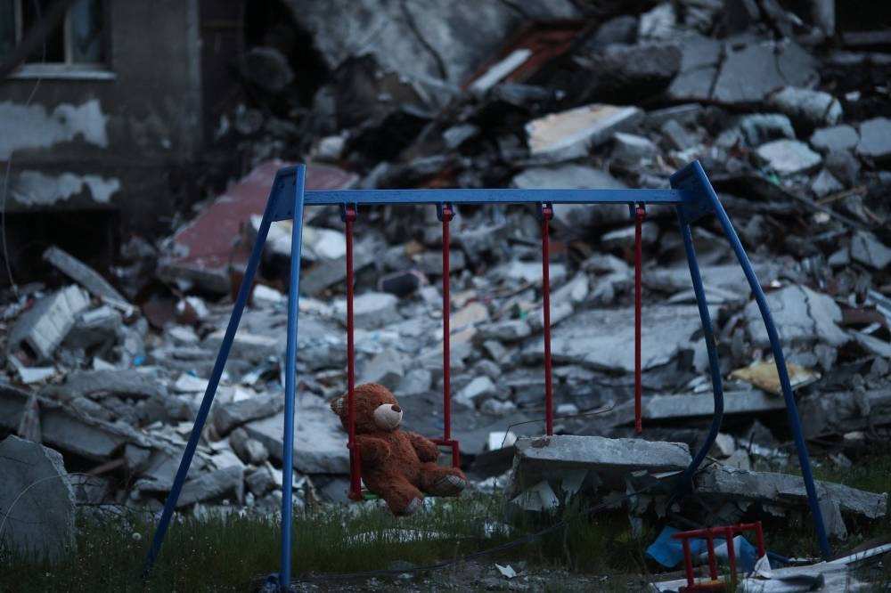 A teddy bear hangs on a swing next to a damaged building in Saltivka district, amid Russia's attack on Ukraine, in Kharkiv, Ukraine May 17, 2022. ― Reuters pic