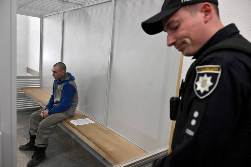 Russian soldier Vadim Shishimarin sits in the defendant’s box on the second day of his trial on charges of war crimes for having killed a civilian, at a courthouse in Kyiv on May 19, 2022. — AFP pic