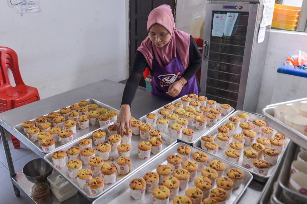 A worker arranges cookies and pastry at the Hidayah Cookies headquarters in Sg Kandis on May 18, 2022. — Picture by Miera Zulyana