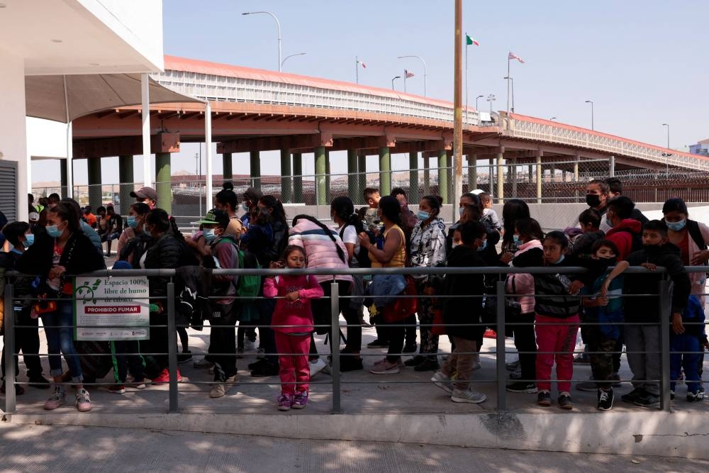 Asylum-seeking migrants, who abandoned their shelter in the Casa del Migrante, wait outside the office of the Center for Integral Attention to Migrants to request information about their asylum in the United States in Ciudad Juarez, Mexico May 18, 2022. — Reuters pic