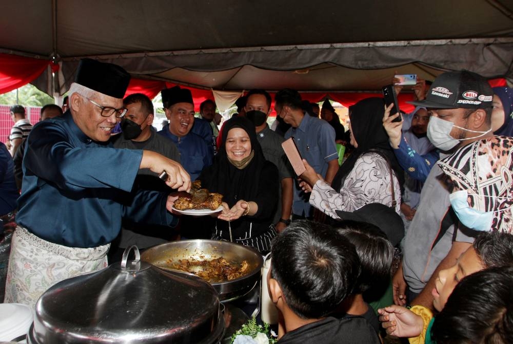 Datuk Seri Hamzah Zainudin (left) distributing food to guests at the Home Minister's Hari Raya Aidilfitri celebration at the Selama District Council Hall May 21, 2022. — Bernama pic