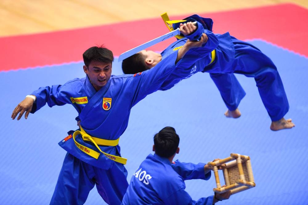 In this file photo taken on May 20, 2022, Laos’ team competes in the men’s multiple weapon practice category of the vovinam event during the 31st Southeast Asian Games (SEA Games) in Hanoi. ― AFP pic