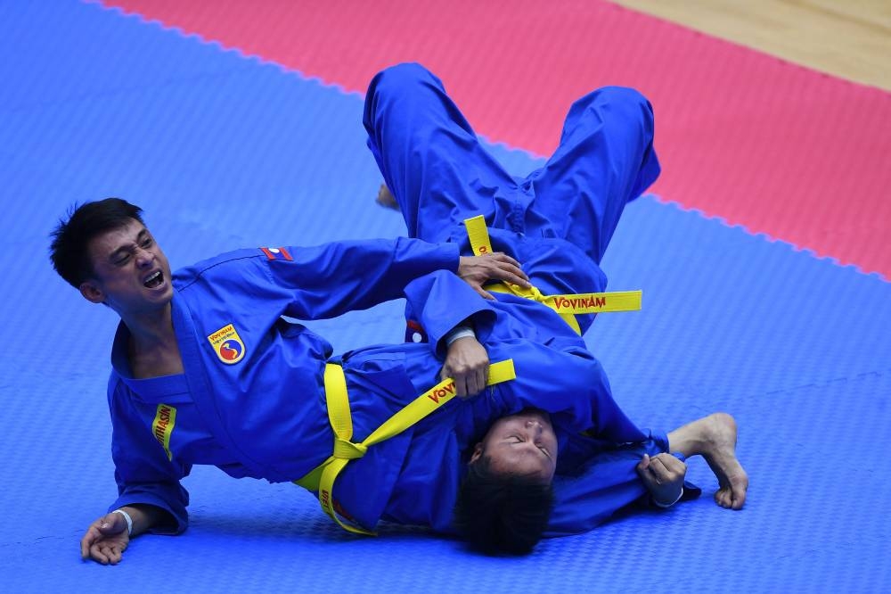 Laos’ team competes in the men’s multiple weapon practice category of the vovinam event during the 31st Southeast Asian Games (SEA Games) in Hanoi on May 20, 2022. ― AFP pic