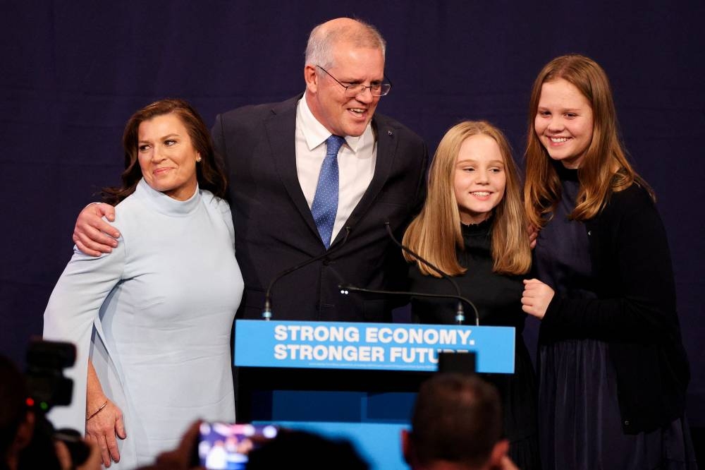 Incumbent Prime Minister Scott Morrison, leader of the Australian Liberal Party, stands next to his wife Jenny and daughters Lily and Abbey as he addresses supporters and concedes defeat in the country's general election in which he ran against Labour Party leader Anthony Albanese, in Sydney, Australia, May 21, 2022. ― Reuters pic