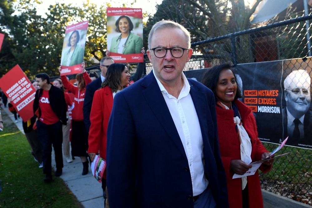 Australian Opposition Leader Anthony Albanese and Labour candidate for the seat of Higgins Michelle Ananda-Rajah react at a polling booth at Carnegie Primary school on the Federal Election day in Carnegie, Australia May 21, 2022. ― Reuters pic