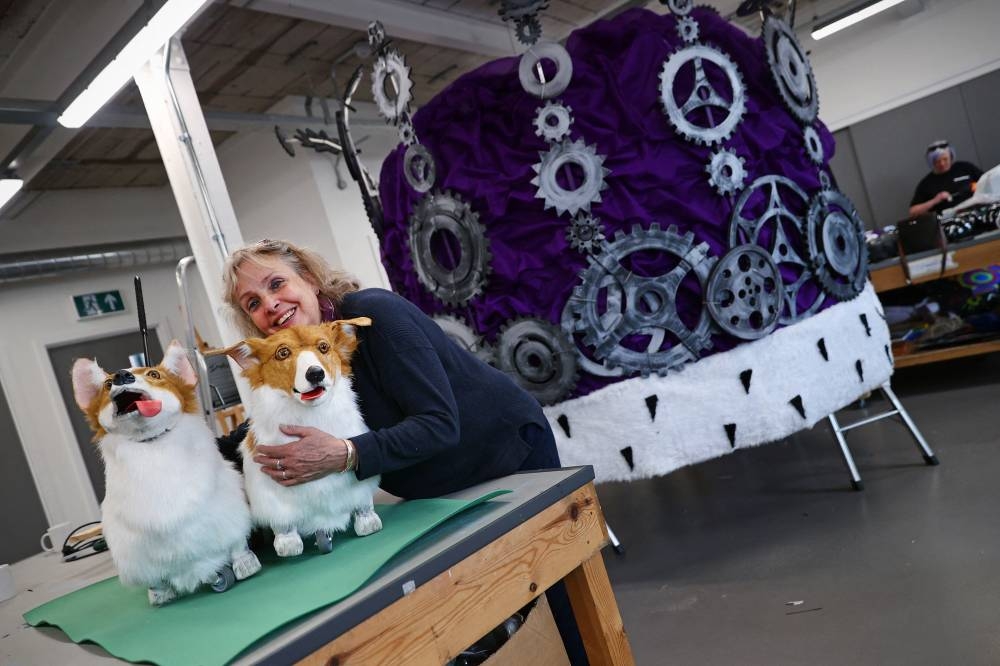 Jane Hytch, Chief Executive of Imagineer, hugs a life-sized model of a corgi dog beside a giant model of a crown in the company's workshop in Coventry May 20, 2022. — AFP pic