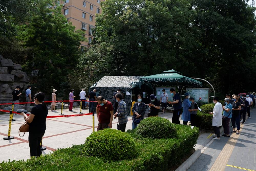 People line up to get tested at a makeshift nucleic acid testing site, amid the Covid-19 outbreak, in Beijing, China May 23, 2022. — Reuters pic