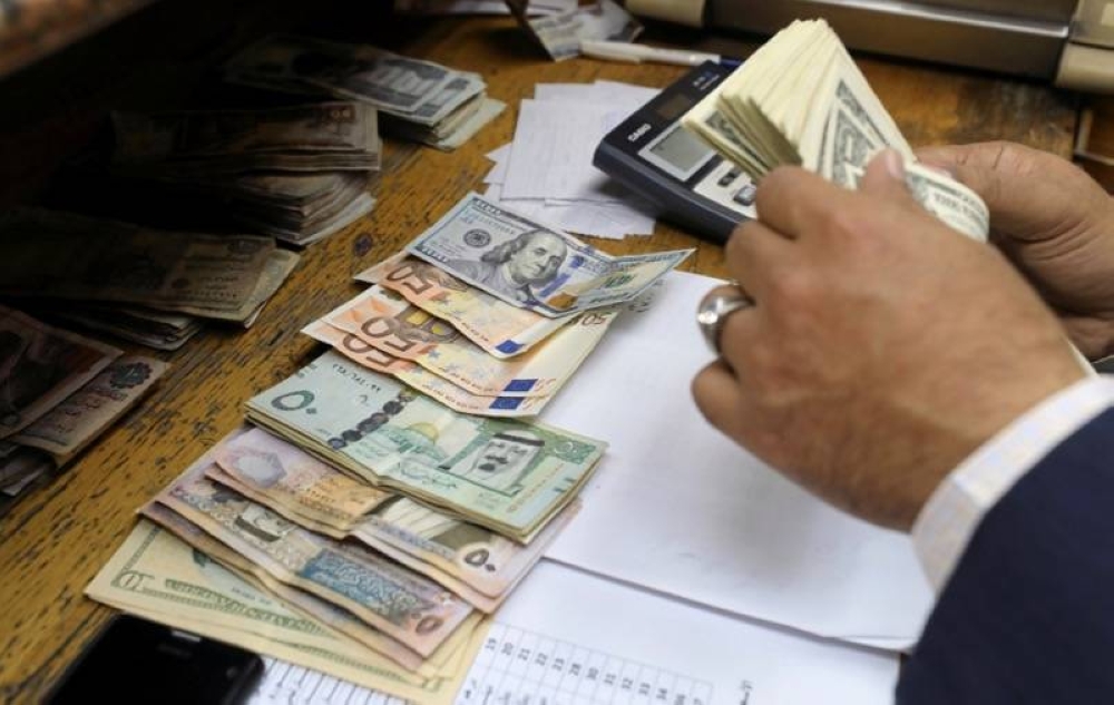 A man counts US dollar and Euro banknotes at a money exchange office in central Cairo, March 9, 2017. — Reuters pic