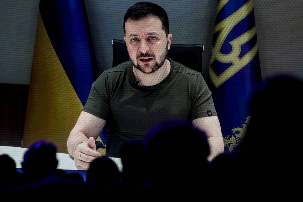 Ukraine’s President Volodymyr Zelensky is seen on a screen as he delivers a video address to the delegates of the World Economic Forum in Davos, Switzerland May 23, 2022. — Reuters pic