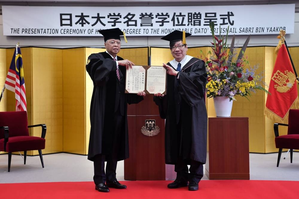 Prime Minister Datuk Seri Ismail Sabri Yaakob receives an honourary doctorate in Medicine from Nihon University president Dr Naoto Kato in Tokyo May 24, 2022. — Bernama pic