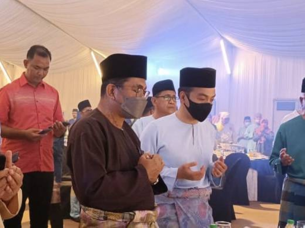 Datuk Seri Mohamed Khaled Nordin (front left) is seen with Johor Mentri Besar Datuk Onn Hafiz Ghazi at the Pasir Gudang Umno Aidilfitri celebration at Dewan Puncak Kasih in Bukit Layang-Layang May 23, 2022. — Picture by Ben Tan