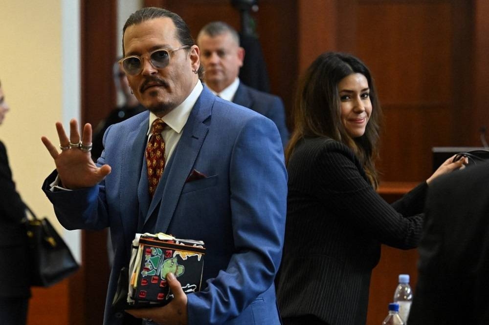 US actor Johnny Depp gestures while departing the courtroom at the Fairfax County Circuit Courthouse in Fairfax, Virginia May 24, 2022. — AFP pic