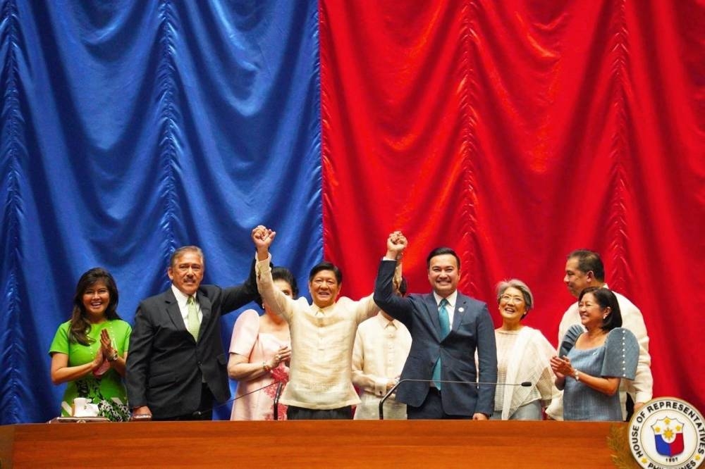 Philippine President-elect Ferdinand ‘Bongbong’ Marcos Jr. raises hands with Senate President Vicente Sotto III and House Speaker Lord Allan Velasco during his proclamation, at the House of Representatives, in Quezon City, Metro Manila, Philippines, May 25, 2022. — BBM Media Bureau handout via Reuters