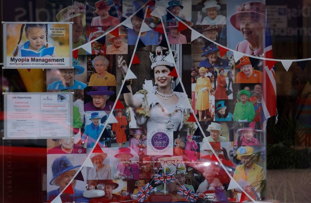 Photographs are displayed in a shop window ahead of planned celebrations for the Queen's Platinum Jubilee in Stony Stratford, Britain May 24, 2022. — Reuters pic