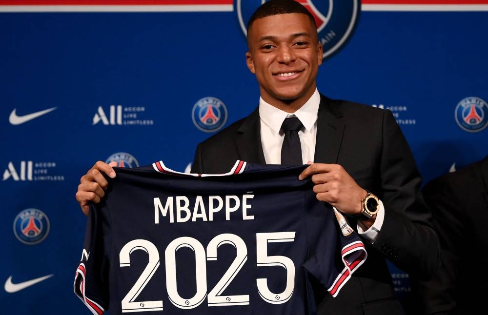Paris Saint-Germain forward Kylian Mbappe poses with a jersey at the end of a press conference at the Parc des Princes stadium in Paris May 23, 2022. — AFP pic 