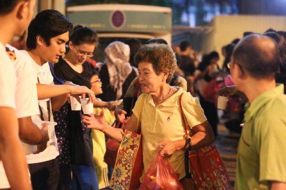 File picture of an elderly woman receiving food given out by the Pertiwi soup kitchen at Jalan Tuanku Abdul Rahman. — Picture by Choo Choy May