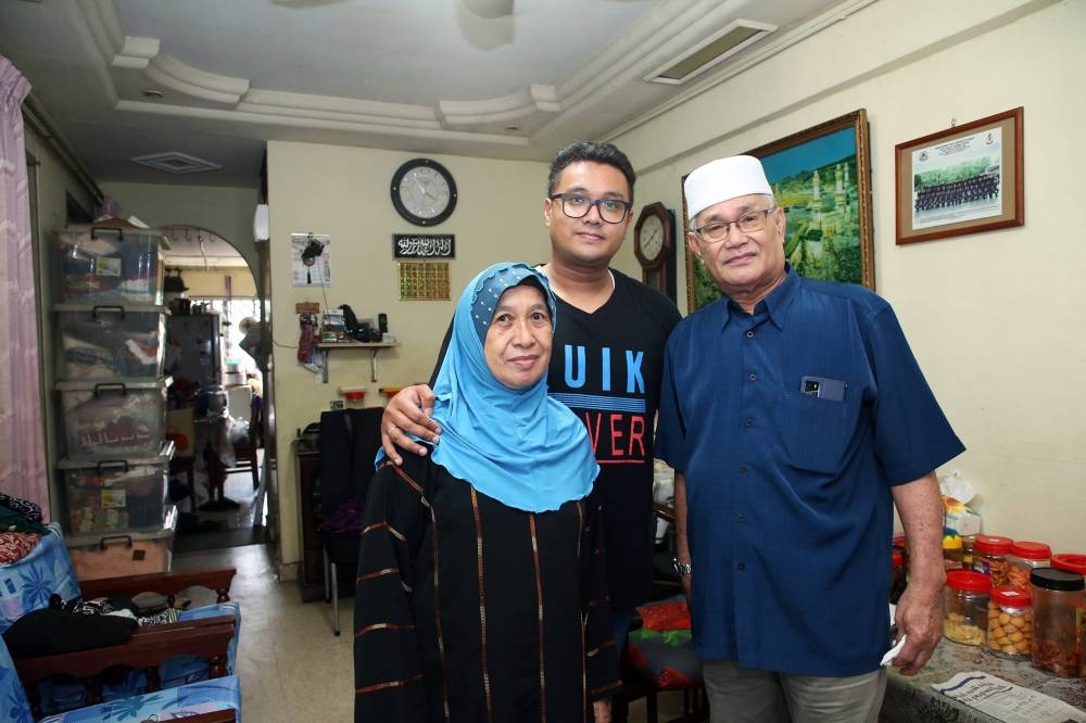 Md Nurezwan Mazlan, 31, with his parents, Moharani Mahadi, 72 and Mazlan Long, 73, at their flat in Block 218, Marsiling Crescent, on May 26, 2022. — TODAY pic