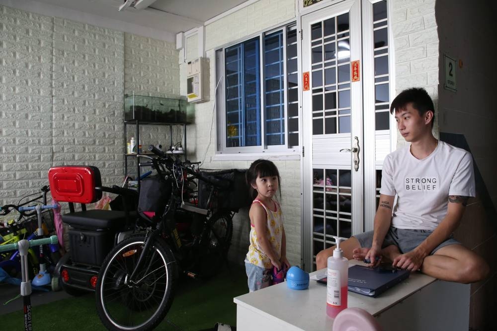 Sebastian Ng, 26, and his six-year-old daughter outside his flat at Block 218, Marsiling Crescent, on May 26, 2022. — TODAY pic