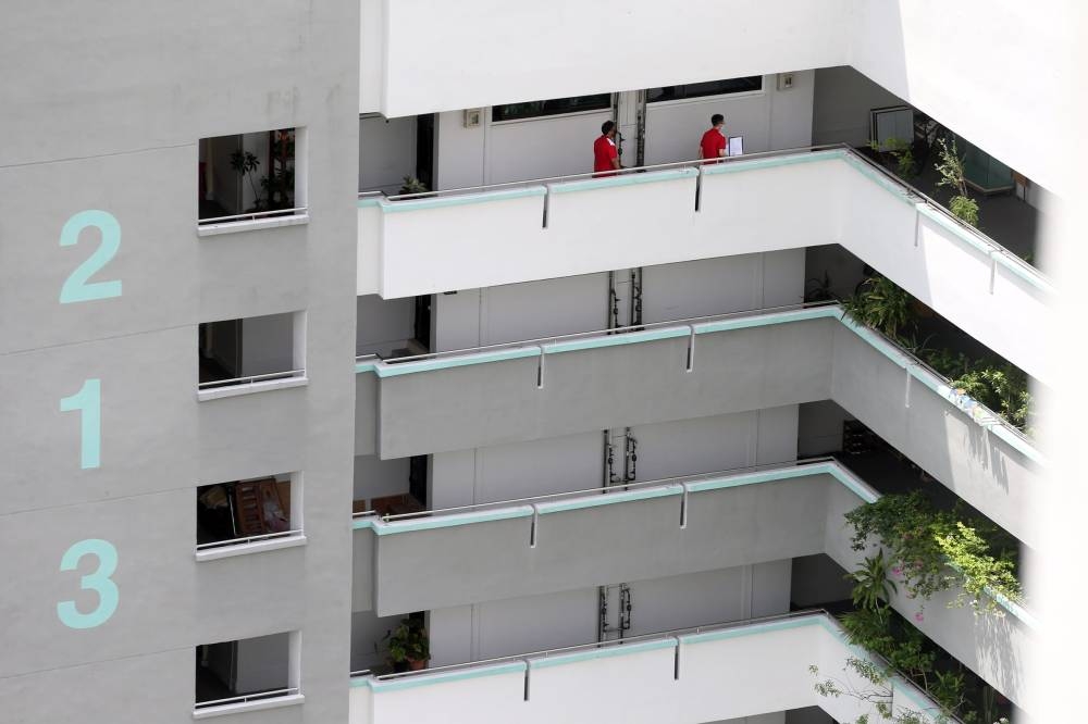 Personnel from the Housing and Development Board going from unit to unit at Block 213, Marsiling Crescent, to inform residents of the acquisition of their flats on May 26, 2022. — TODAY pic