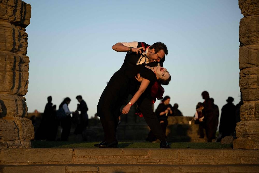 Vampires gather in the grounds of Whitby Abbey following a successful Guinness world record attempt to gather the largest number of vampires together in one place, in Whitby, north-east England on May 26, 2022. — AFP pic