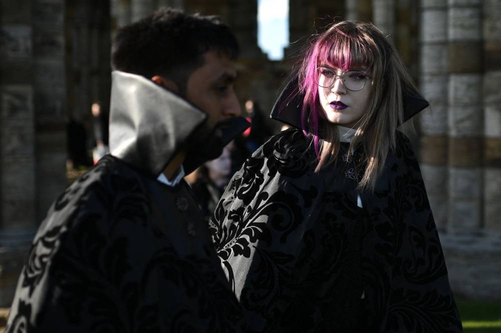 Vampires wait in the grounds of Whitby Abbey ahead of a Guinness world record attempt to gather the largest number of vampires together in one place, in Whitby, north-east England on May 26, 2022. — AFP pic