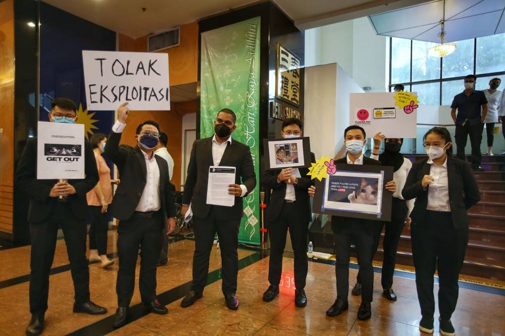 Members of the Young Lawyers Movement hold placards during a protest at Wisma MCA, where the Malaysian Bar Association was holding an EGM, in Kuala Lumpur on May 27, 2022. — Photo by Ahmad Zamzahuri