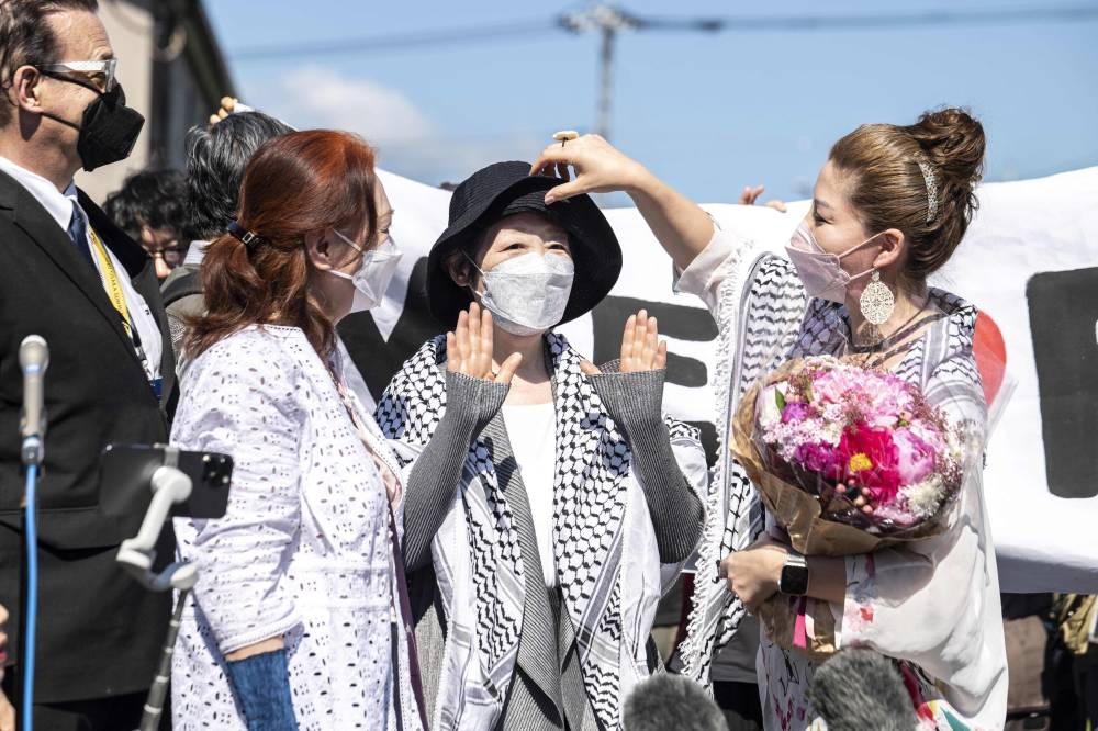 Japanese Red Army founder Fusako Shigenobu (centre) after her release from jail, talks to journalists in Akishima, Tokyo prefecture on May 28, 2022. ― AFP pic