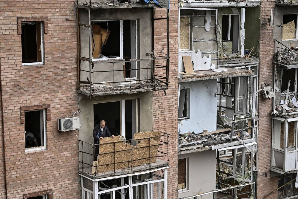 A man stands on the balcony of his destroyed apartment in Bakhmut in the eastern Ukranian region of Donbas on May 25, 2022. — AFP pic