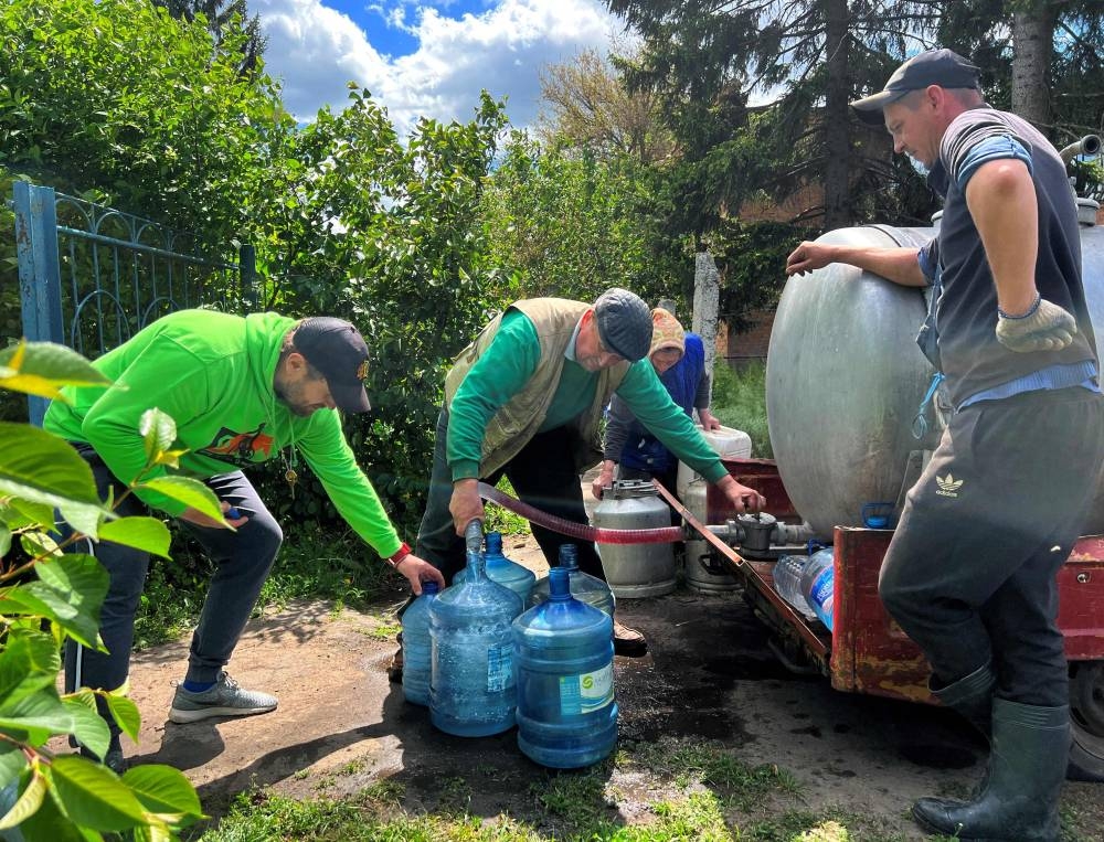 Residents fill cans from a water distribution tanker in the village of Kutuzivka, Kharkiv region, on May 27, 2022, amid the Russian invasion of Ukraine. — AFP pic