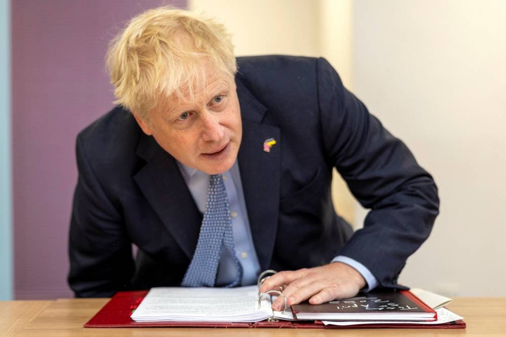 File photo of British Prime Minister Boris Johnson taking a seat during a visit to the CityFibre Training Academy in Stockton-on-Tees, Britain May 27, 2022. — Reuters pic
