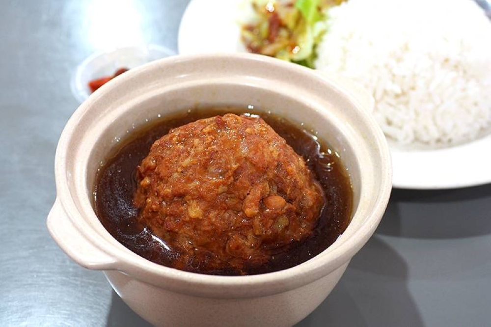 The lion head rice is comfort food with a fluffy meatball paired with rice and cabbage.