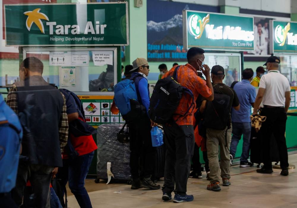 A group of mountaineers wait to board a flight as they head to search and rescue of a plane operated by Tara Air that went missing on Sunday with 22 people on board, while on its way to Jomsom, in Kathmandu, Nepal May 29, 2022. — Reuters pic 