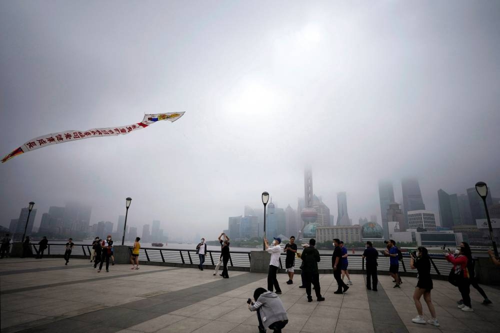A man flies a kite to mark the Children's Day on the Bund, after the lockdown placed to curb the coronavirus disease outbreak was lifted in Shanghai June 1, 2022. — Reuters pic