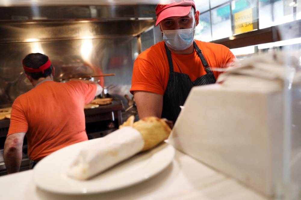 A cook prepares a souvlaki, a popular Greek fast food made with pieces of meat grilled on a skewer, in a restaurant, in Athens May 27, 2022. — Reuters pic