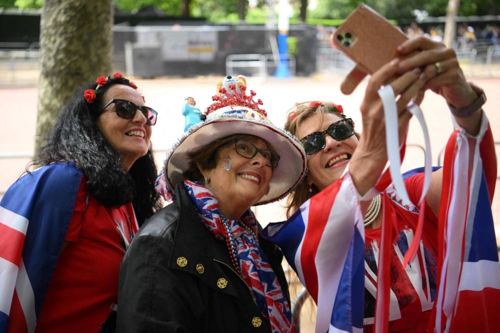 Visitors dressed-up with Britain's national colours take a selfie picture as they gather at The Mall, in London, on June 1, 2022 ahead of the Platinum Jubilee's celebrations for Britain's Queen Elizabeth II. — AFP pic