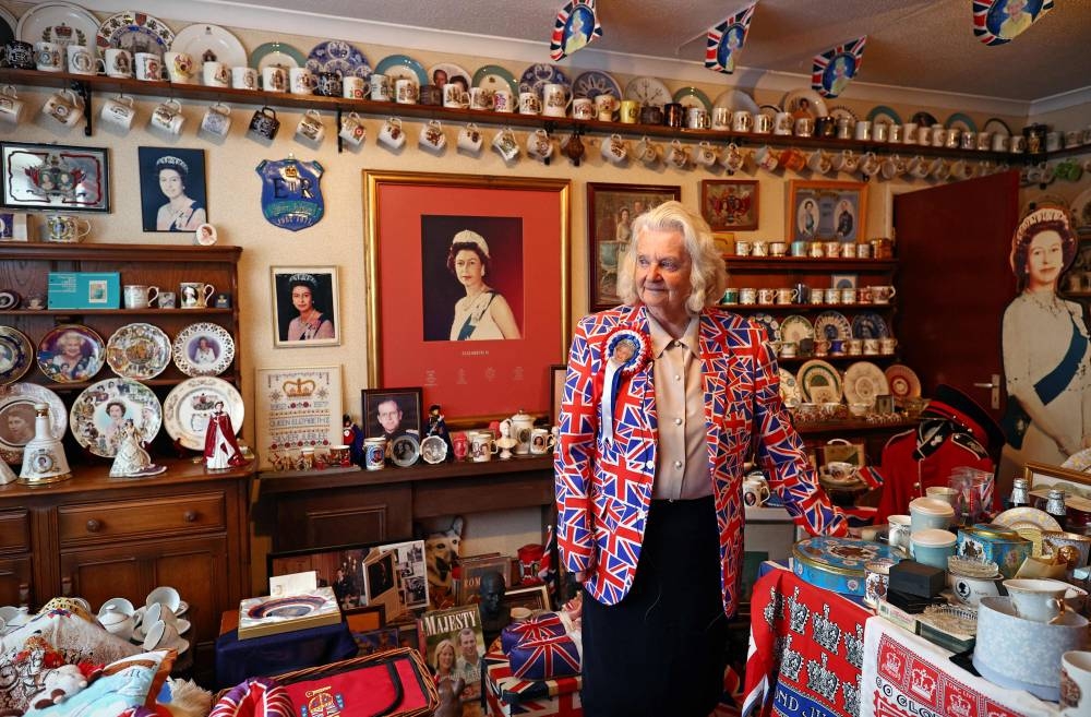 Royal super-fan Margaret Tyler poses for a photograph with her collection of Royal memorabilia in her ‘Jubilee room’ at home in London on May 30, 2022. — AFP pic 