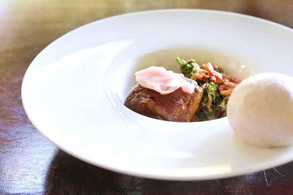 Organic pork belly is used for moo hong, accompanied by a riceberry 'mantou' bun.
