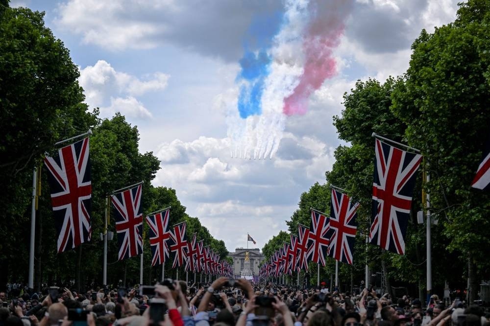 People gathered on The Mall watch a fly-past over Buckingham Palace during celebrations marking the Platinum Jubilee of Britain's Queen Elizabeth, in London, Britain, June 2, 2022. — Reuters pic