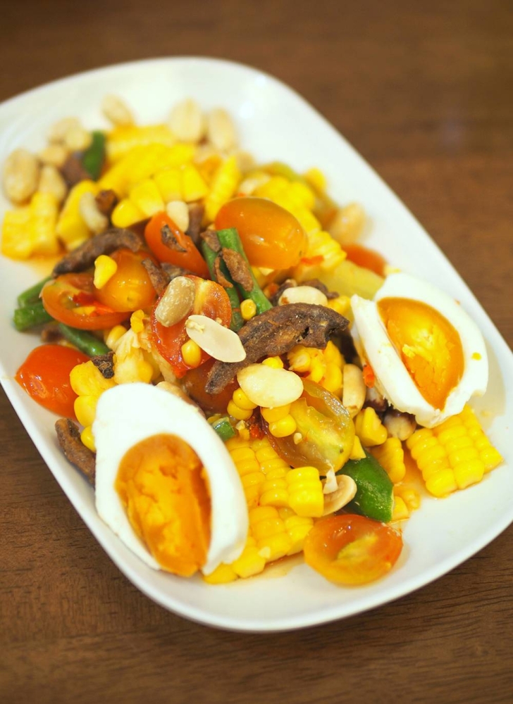 For a different salad, there's a corn and tomato salad served with salted eggs.