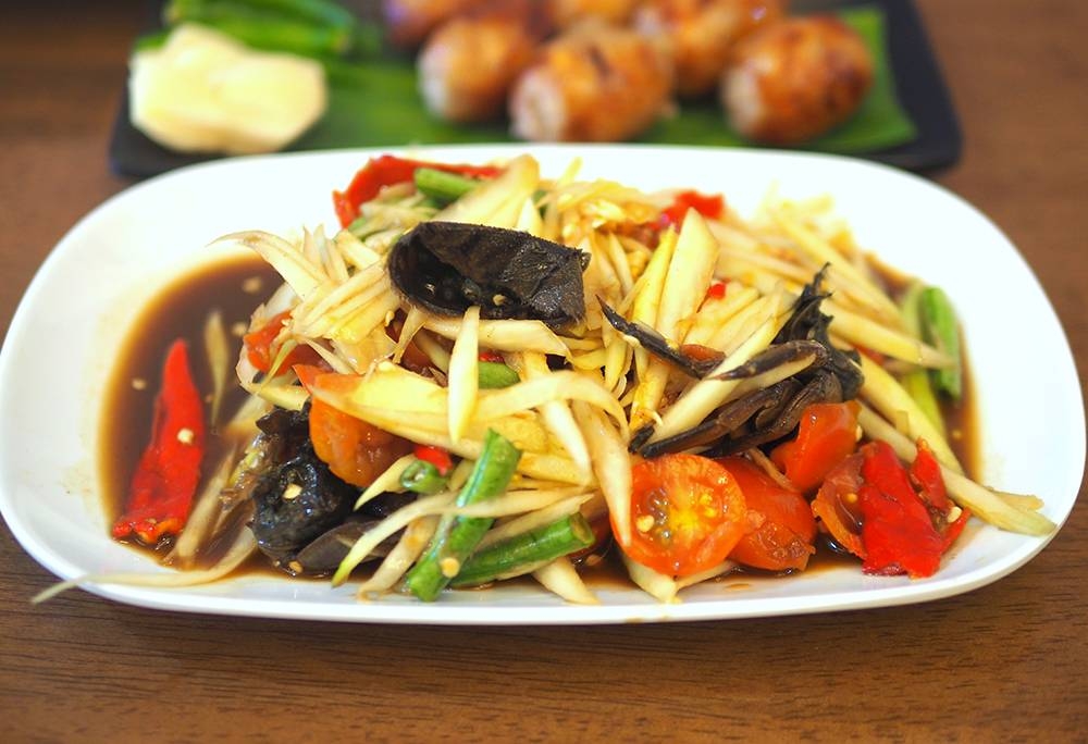 The crowd favourite 'tam poo plara' or papaya salad is served with pickled crabs here.