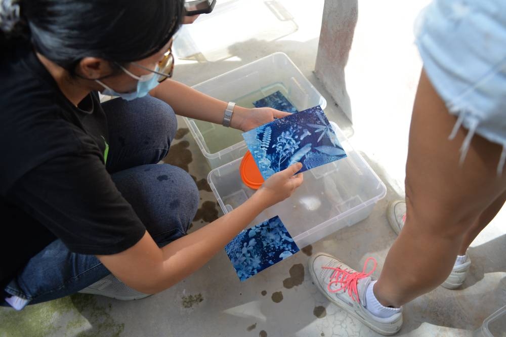 A participant at ImagiNasi tries her hand at making art using wild flora. UBI aims to use cultural activities to promote its message of environmental conservation.