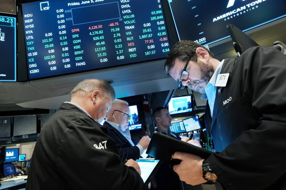 Traders work on the floor of the New York Stock Exchange (NYSE) at the start of the trading day on June 03, 2022 in New York City. A new jobs report released by the Labor Department this morning shows employers added 390,000 jobs in May. — AFP pic