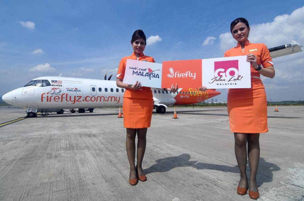 Flight attendants holding posters bearing the Firefly with 50 Years of Tourism Malaysia logo during the Fire Fly Livery Launch and #Gojalanlah Campaign at Sky Park RAC, Industrial Park Bukit Jelutong, Shah Alam, June 4, 2022. — Bernama pic