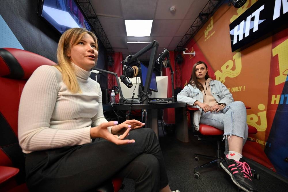 File photo of NRJ radio programming director Julia Vinnychenko (lef) and DJ Yana Manuilova answering to AFP journalists during her broadcast at NRJ radio in Kyiv on April 30, 2022. ― AFP pic