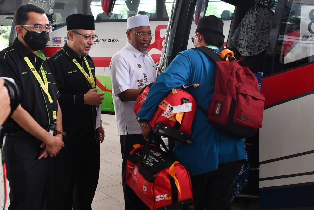 Minister in the Prime Minister’s Department (Religious Affairs) Datuk Idris Ahmad greets Malaysian Haj pilgrims boarding a bus to the airport in Sepang June 4, 2022. — Bernama pic
