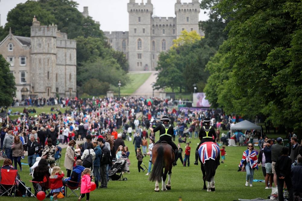 Police officers ride on horses past the crowd as people take part in the Big Jubilee Lunch on The Long Walk as part of celebrations marking the Platinum Jubilee of Britain's Queen Elizabeth, in Windsor June 5, 2022. — Reuters pic