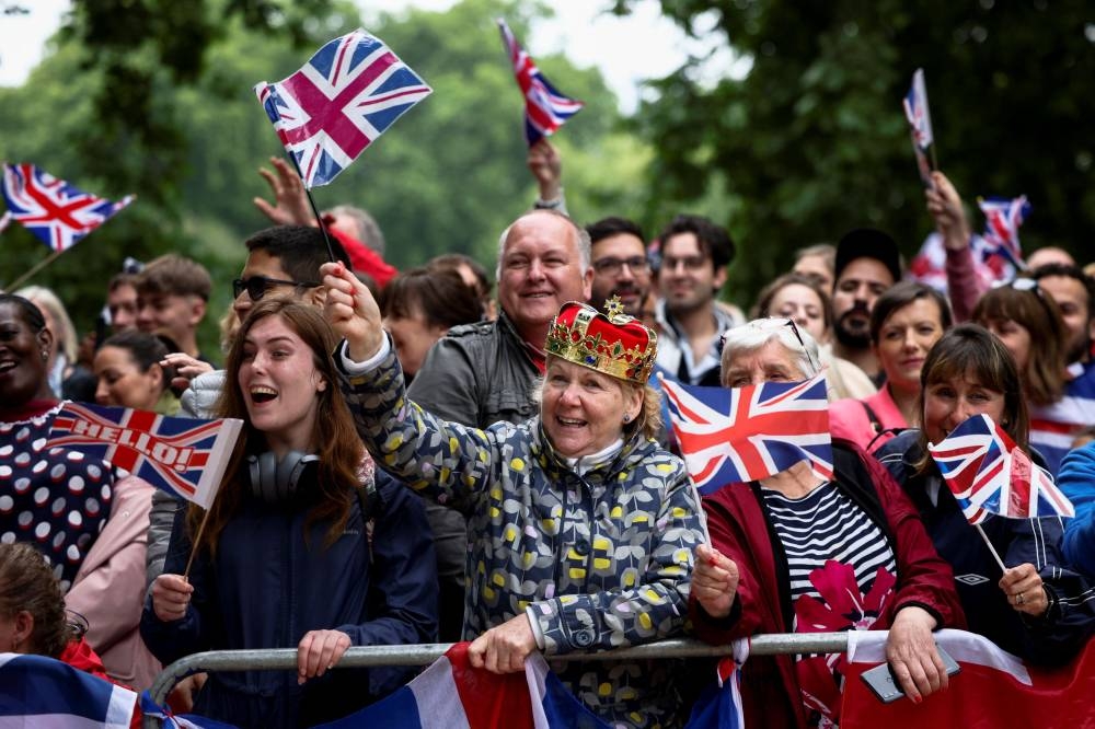 A woman wearing a prop crown waves a Union Jack as people gather on The Mall ahead of the Platinum Jubilee Pageant, marking the end of the celebrations for the Platinum Jubilee of Britain's Queen Elizabeth, in London June 5, 2022. — Reuters pic