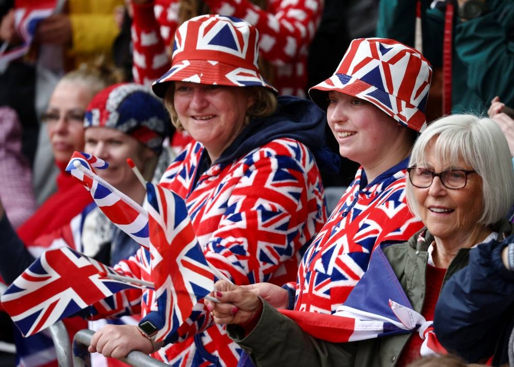 Members of the public wearing Union Jack-themed outfits wave flags as they gather on The Mall ahead of the Platinum Jubilee Pageant, marking the end of the celebrations for the Platinum Jubilee of Britain's Queen Elizabeth, in London June 5, 2022. — Reuters pic